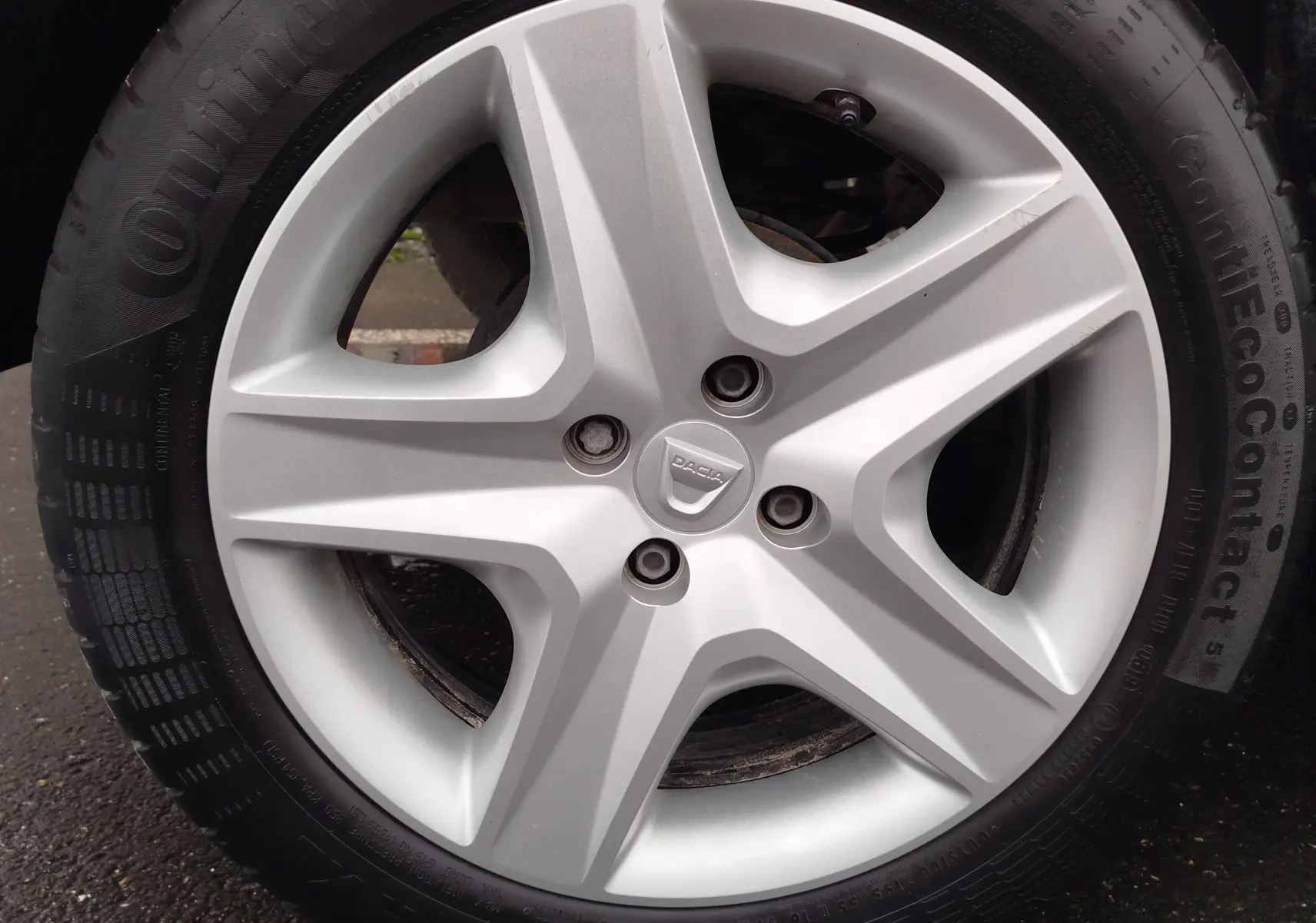 Vue de profil côté gauche d'une Dacia Sandero blanc glacier de 2019 avec jantes visibles sur sol asphalté.