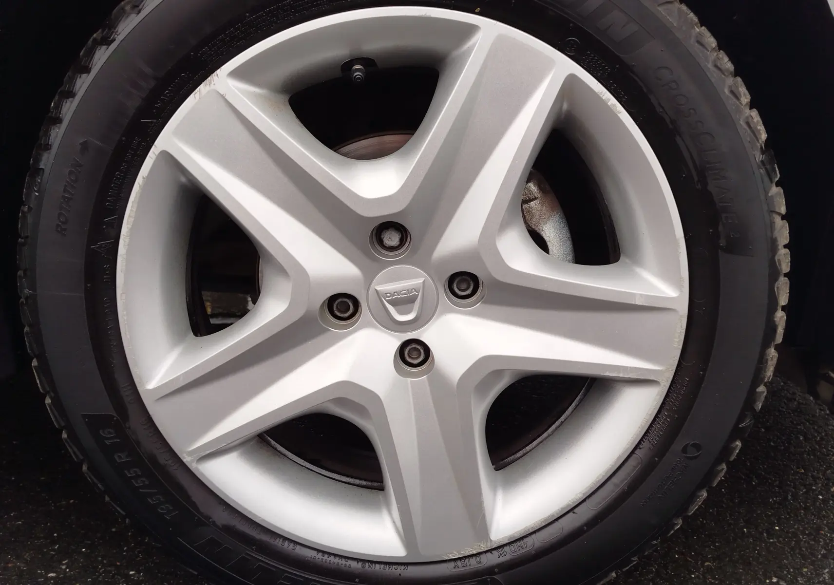 Vue 3/4 avant d'une Dacia Sandero blanc glacier de 2019 avec phares LED et calandre noire distinctive.