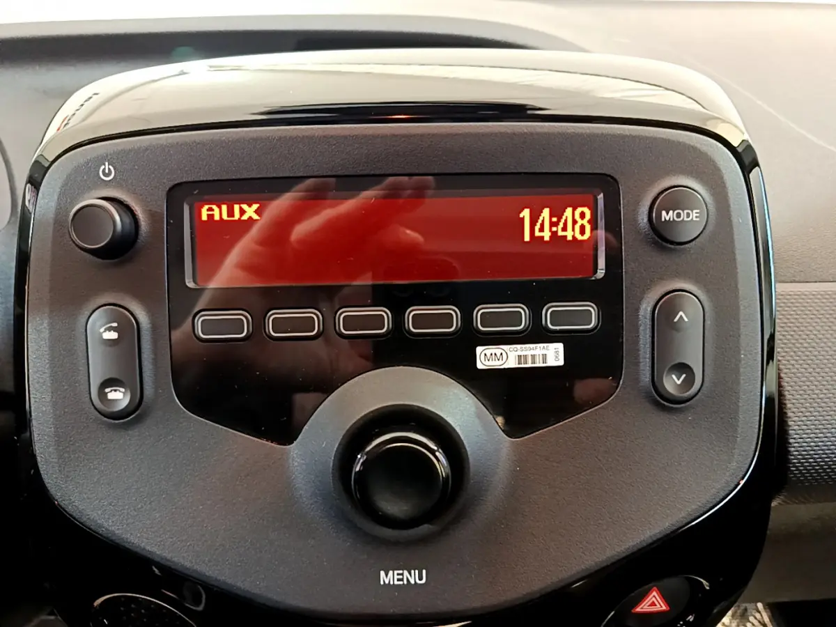 Gros plan sur la console centrale noire de la Citroën C1 2020 avec écran rouge affichant "AUX" et l'heure 14:48.