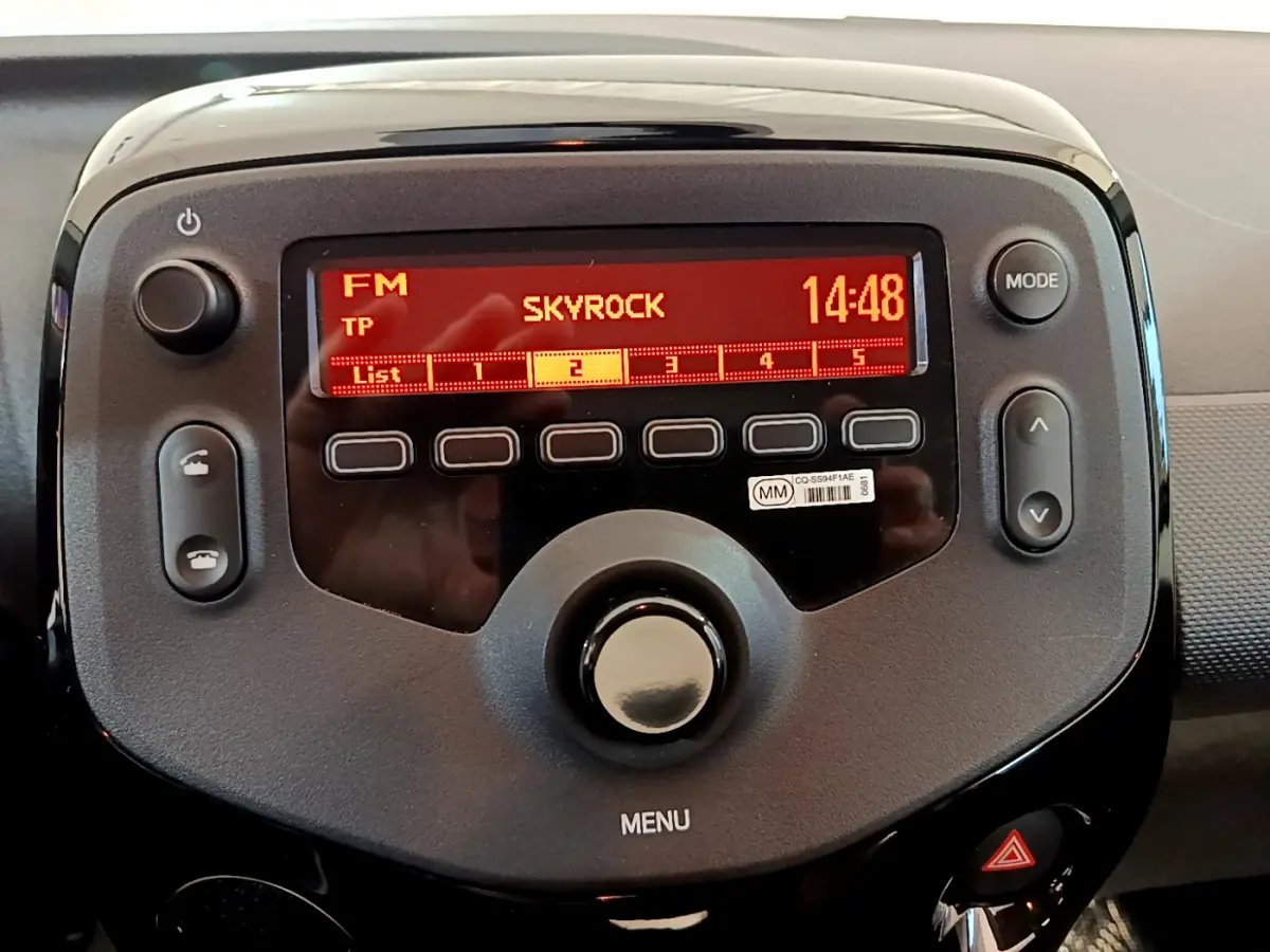 Gros plan sur l’autoradio noir de la Citroën C1 blanc, affichant la radio FM Skyrock à 14h48.