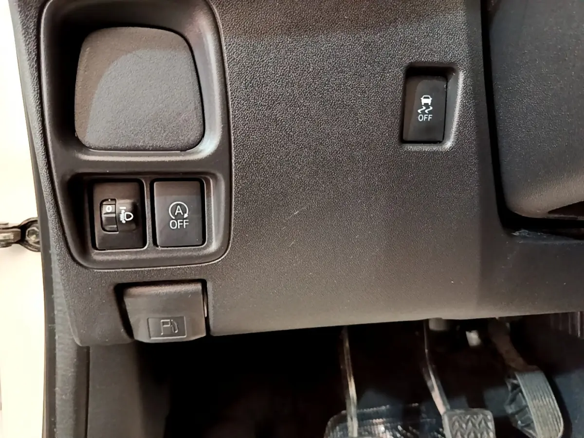 Détail intérieur montrant les commandes de réglage des phares, désactivation start-stop et antipatinage sur Citroën C1 blanche.