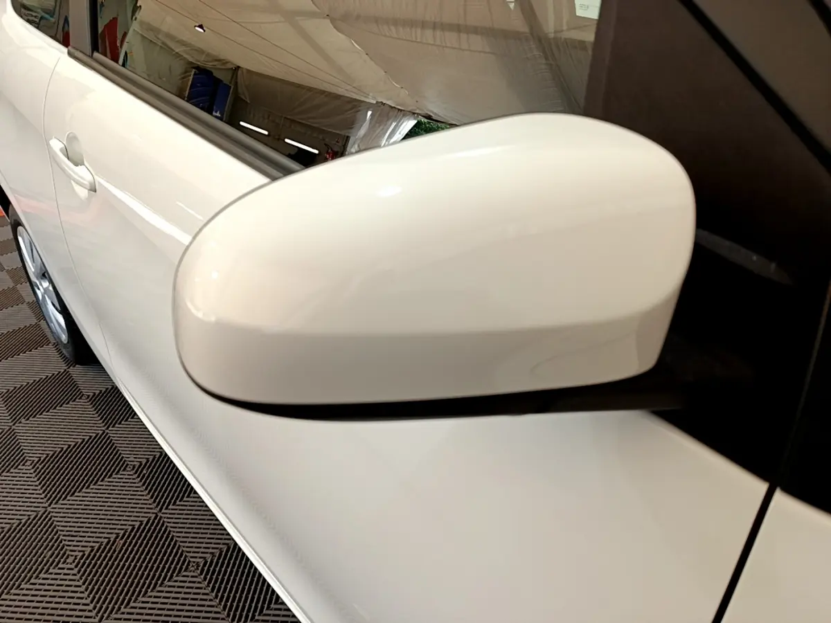 Gros plan sur le rétroviseur côté conducteur blanc d'une Citroën C1 VTi 72 S&S BVM Feel 2020, avec portière visible.