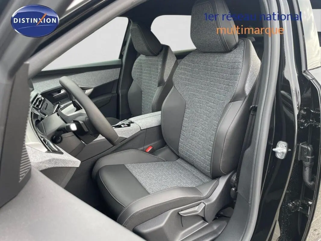 Vue intérieure côté conducteur du Peugeot 3008 noir 2025, sièges tissu et cuir avec volant cuir.