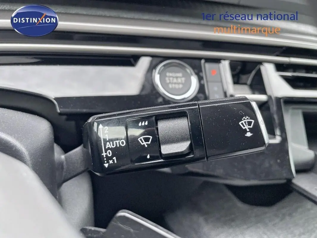 Gros plan sur la commande d’essuie-glace avec bouton auto, volant cuir et bouton start/stop visibles dans un Peugeot 3008 noir.