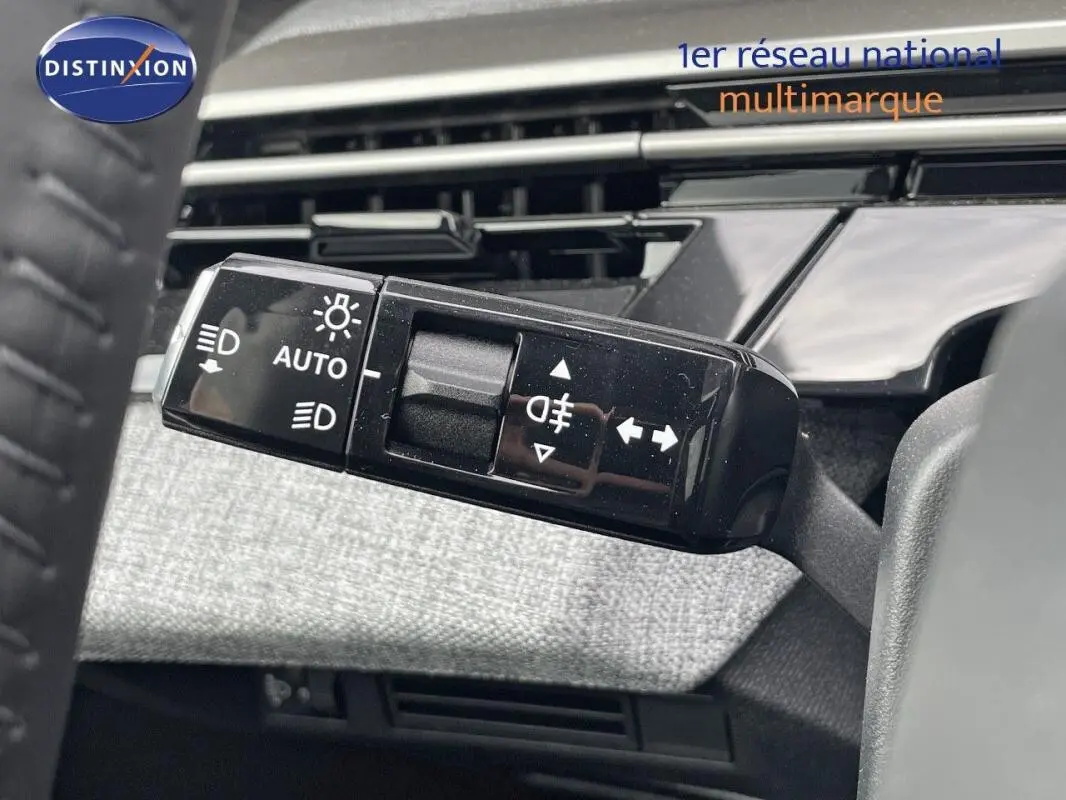 Gros plan sur la commande des feux et clignotants à gauche du volant du Peugeot 3008 noir, intérieur moderne.