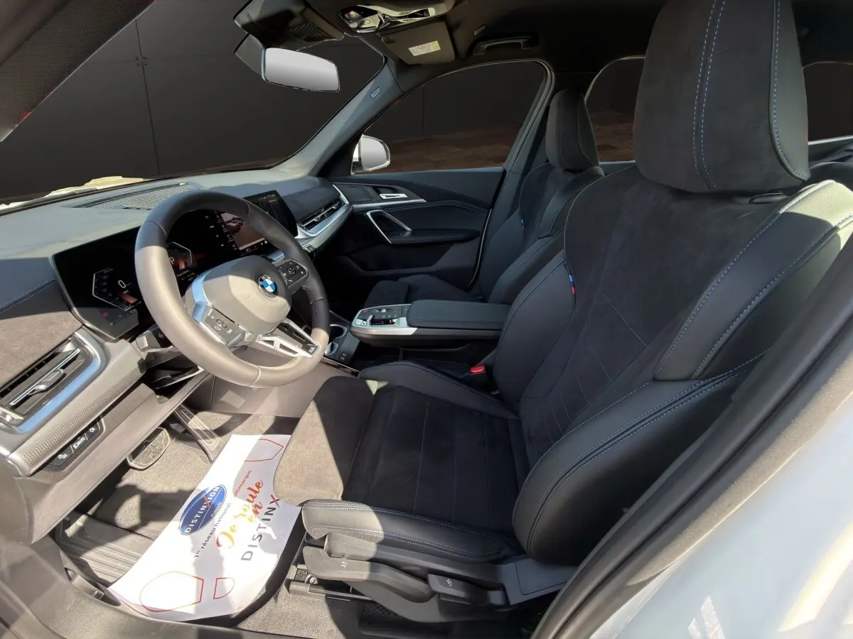 Vue intérieure côté conducteur du BMW X1 sDrive20d M SPORT 2025 avec sièges noirs et tableau de bord moderne.