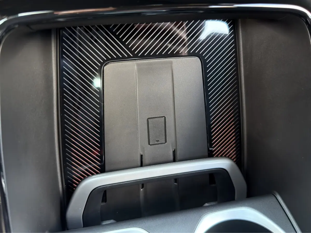 Gros plan sur le chargeur sans fil au centre de la console d'une BMW X1 blanche, finition M SPORT.