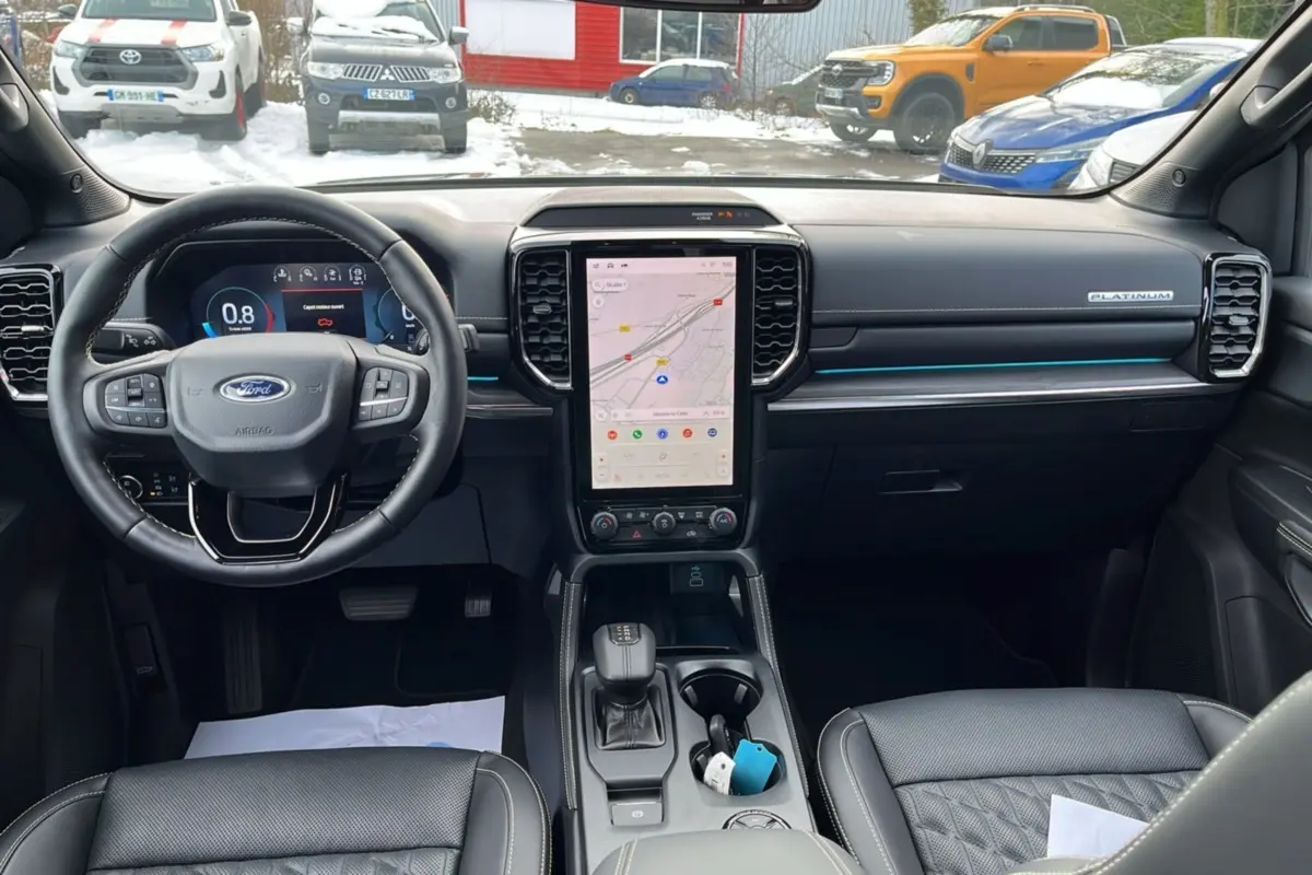 Vue intérieure avant du Ford Ranger Platinum 2026, tableau de bord moderne avec écran tactile vertical et volant cuir multifonctions.