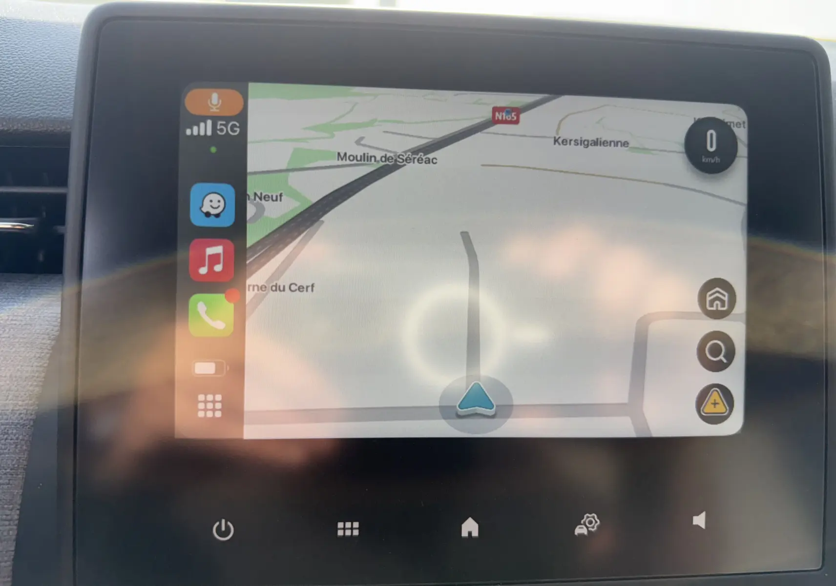 Écran tactile du système de navigation de la Renault Clio gris Rafale, affichant une carte routière avec icônes colorées sur la gauche.
