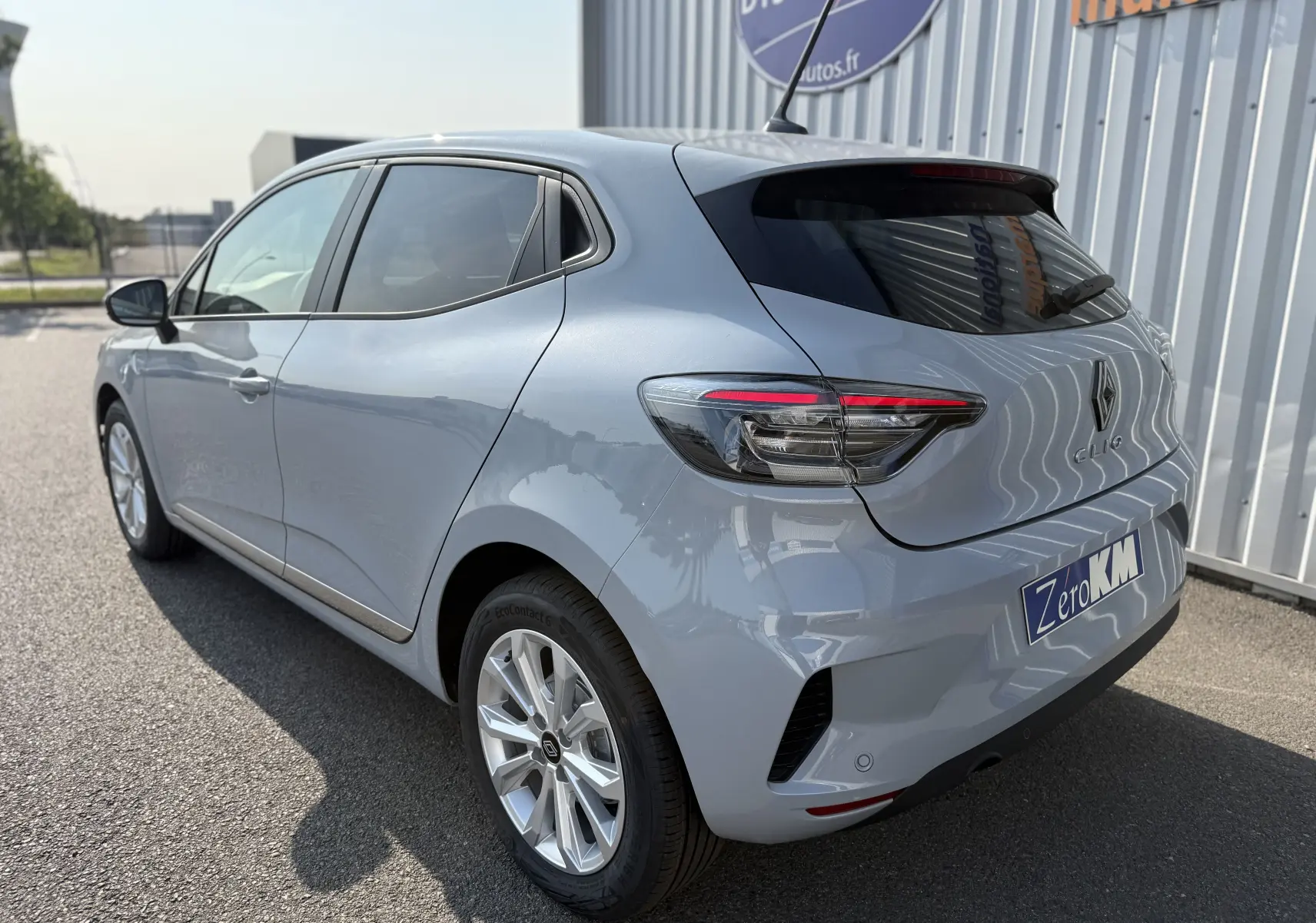 Vue 3/4 arrière droite d'une Renault Clio gris Rafale métal 2025 avec feux arrière LED et plaque Zero KM.