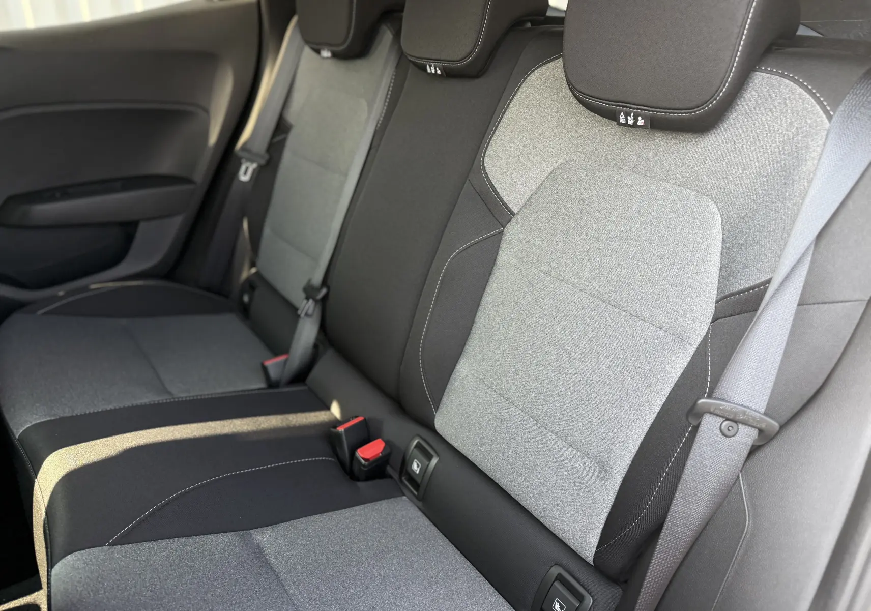 Vue rapprochée des sièges arrière bicolores gris clair et noir de la Renault Clio 2025, version diesel 5 portes.
