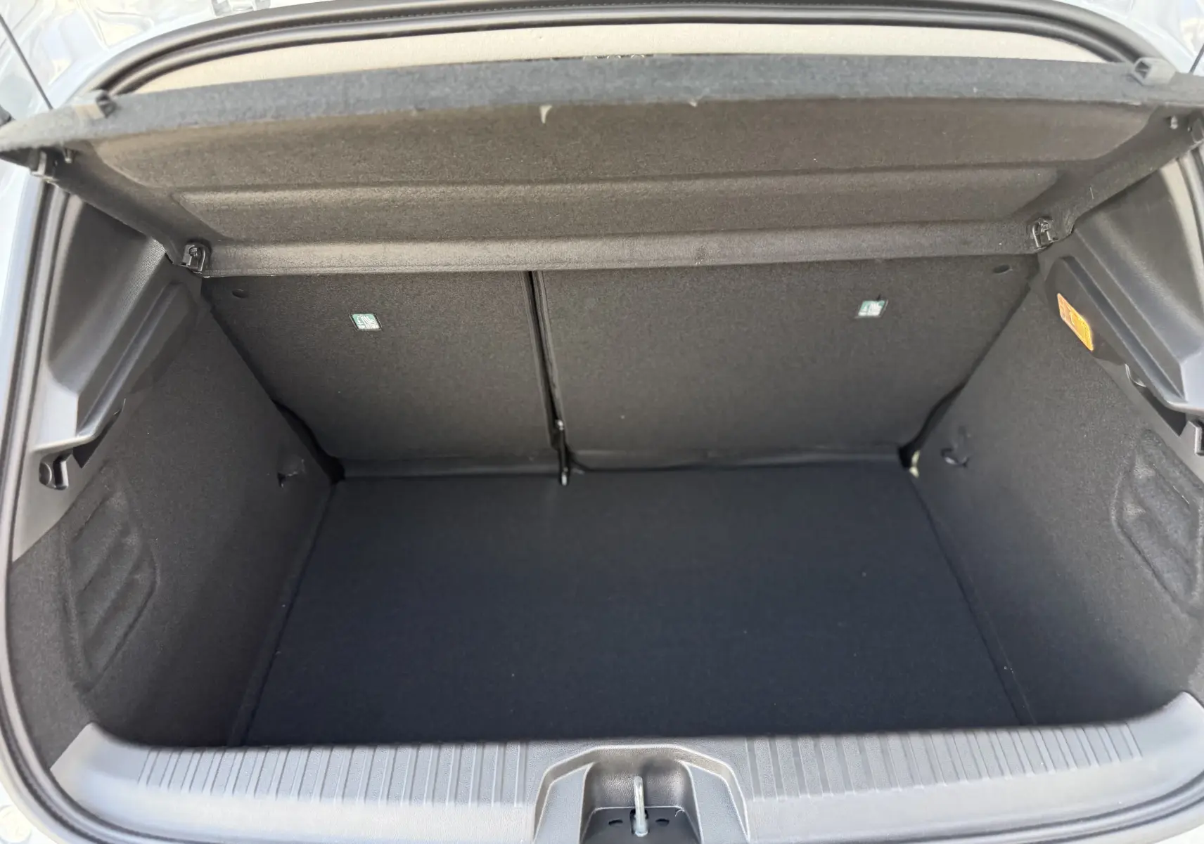 Coffre ouvert vu de dessus d'une Renault Clio gris Rafale Métal, montrant un espace de chargement propre et vide.