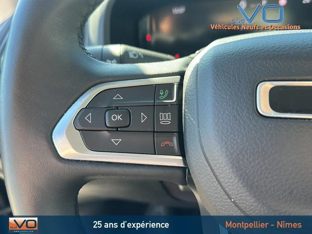 Gros plan sur les commandes gauche du volant noir du Jeep Renegade 2024, avec boutons de navigation et appel téléphonique.