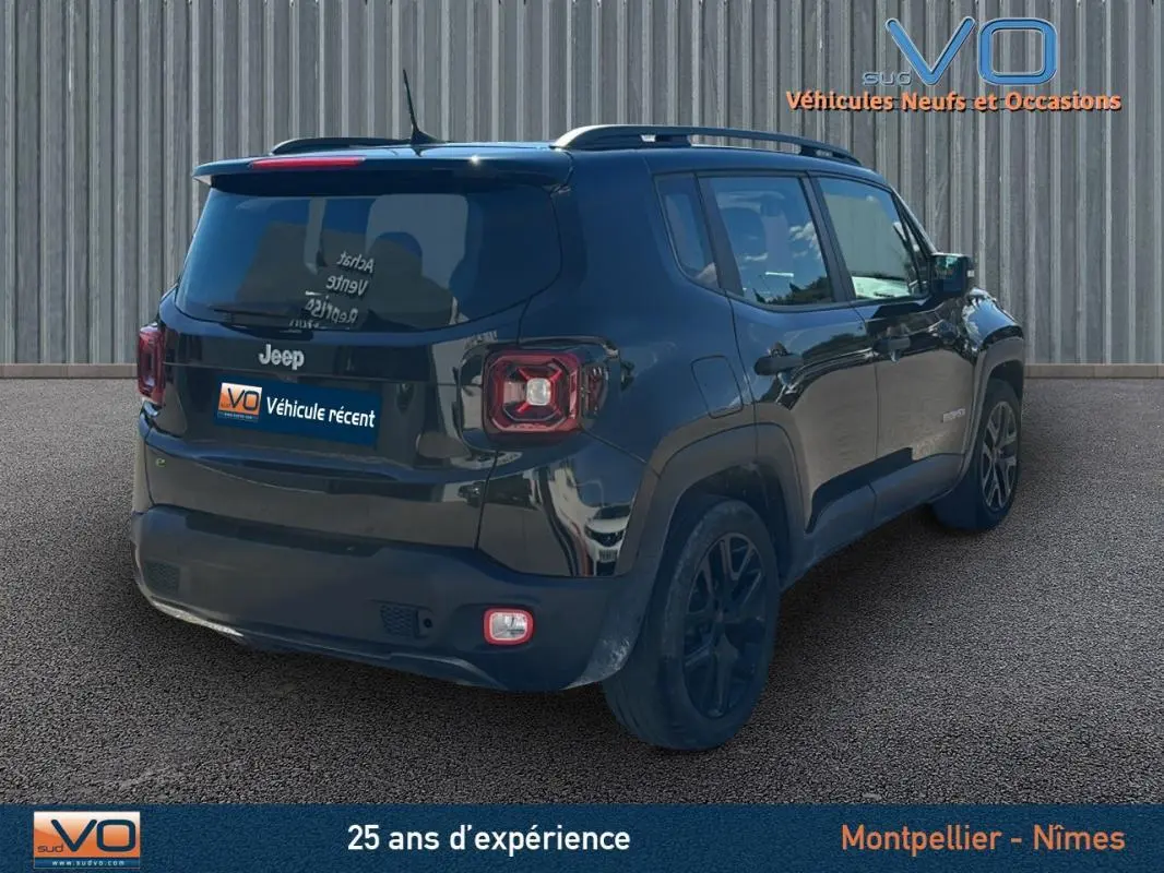 Jeep Renegade noir vue 3/4 arrière droit avec barres de toit et jantes alliage 18 pouces sur sol goudronné