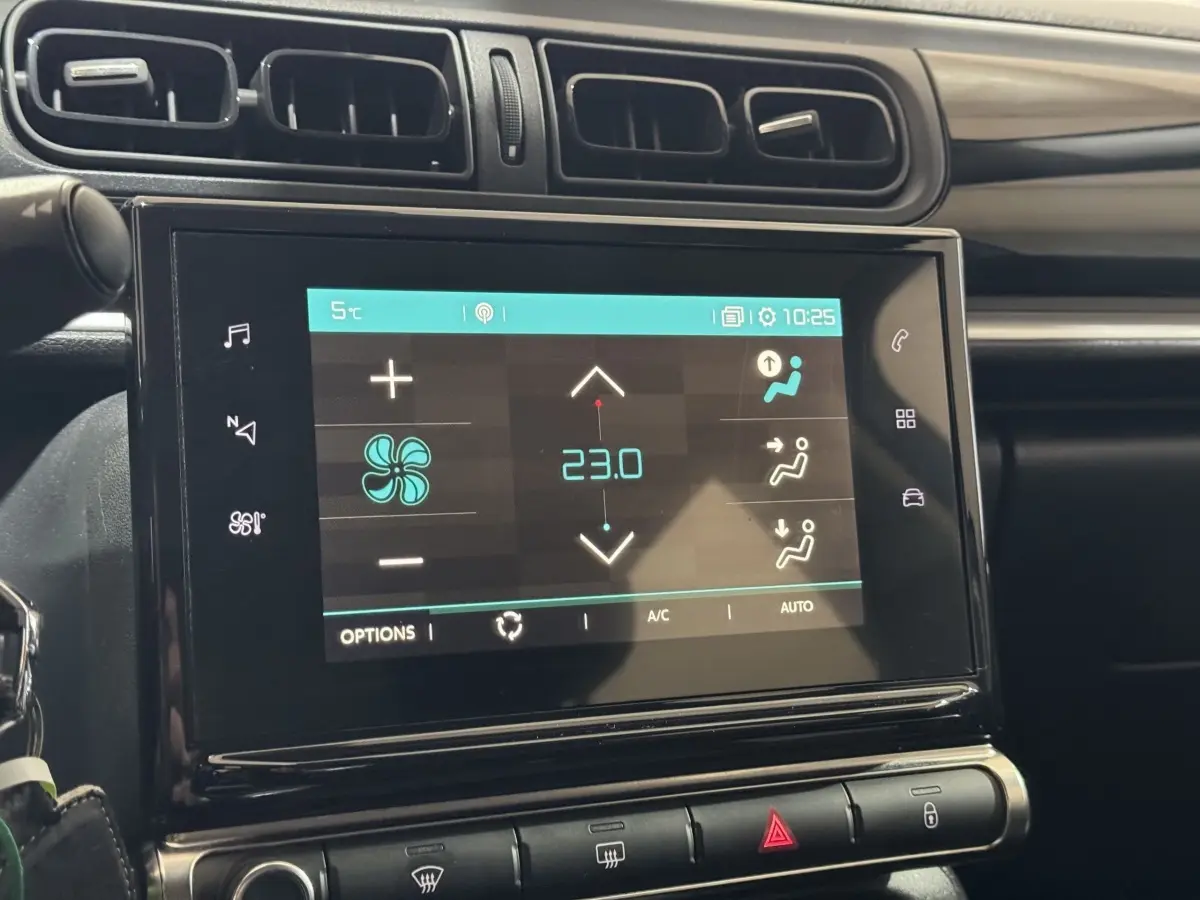 Écran tactile central de la Citroën C3 bleu, affichant la climatisation à 23°C, avec commandes autour en vue intérieure.