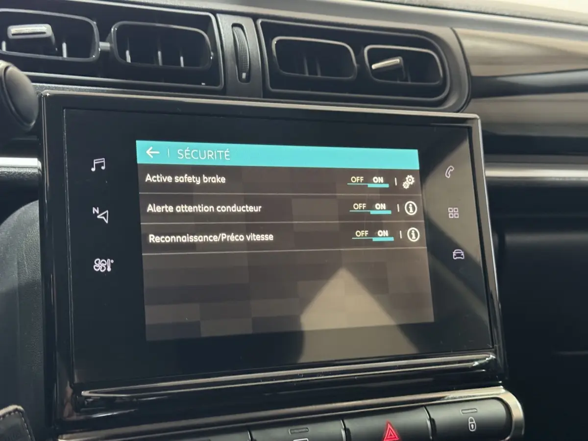 Écran tactile central affichant les réglages de sécurité dans l'habitacle sombre d'une Citroën C3 bleu.