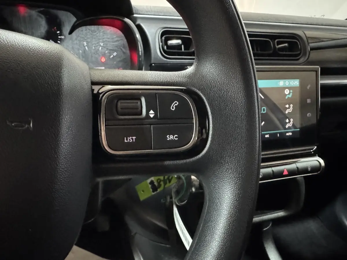 Vue intérieure centrée sur le volant noir avec commandes, écran tactile et tableau de bord de la Citroën C3 bleu.