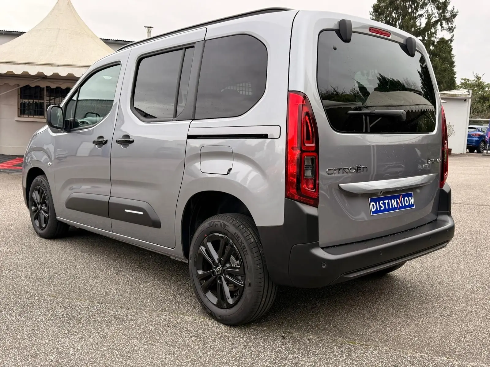 Vue 3/4 arrière droit du Citroën Berlingo gris Artense 2025 avec vitres teintées et jantes noires.