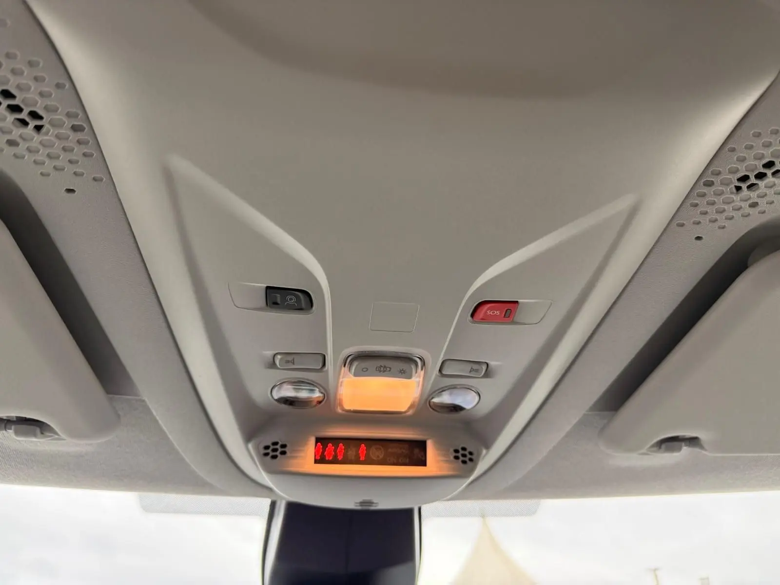Vue intérieure du plafonnier avant du Citroën Berlingo gris, avec commandes d’éclairage et bouton SOS rouge.