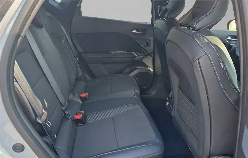 Vue intérieure arrière droite des sièges arrière en tissu gris noir du Renault Captur E-Tech Hybrid 2025, porte ouverte.