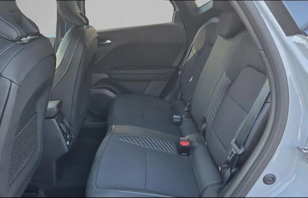 Vue intérieure côté droit des sièges arrière en tissu gris noir du Renault Captur E-Tech Hybrid 2025, avec ceinture de sécurité visible.