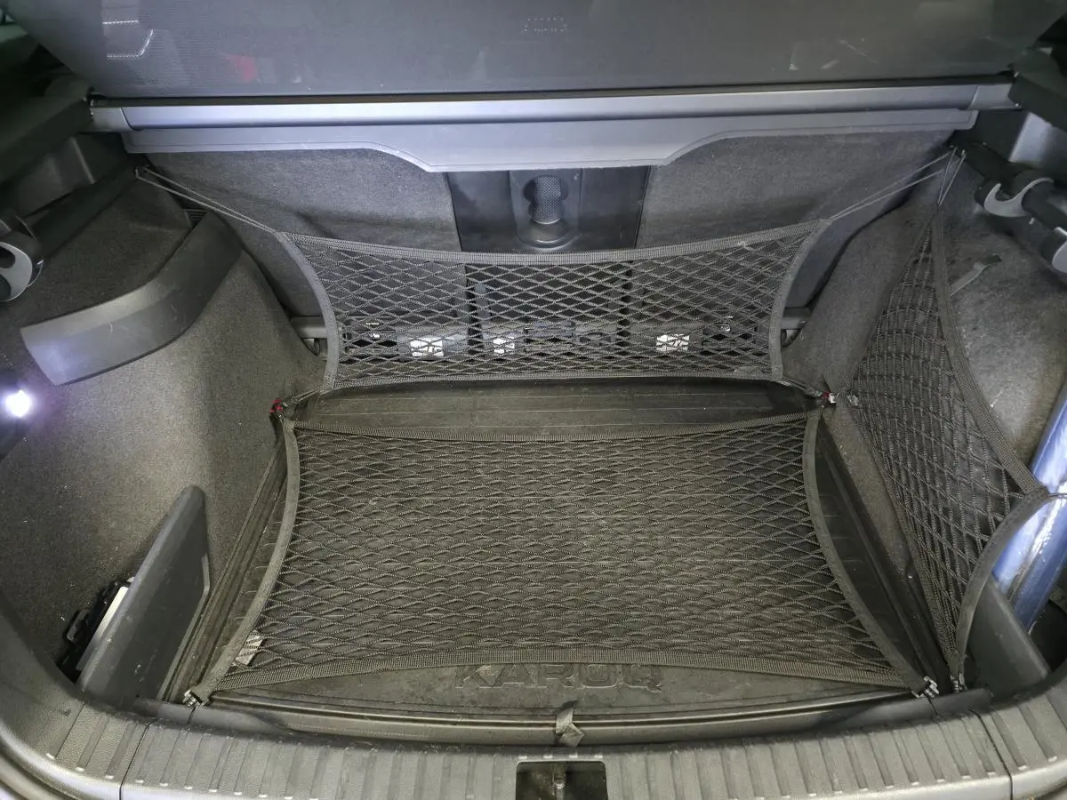 Coffre du Skoda Karoq rouge 2018 vu de dessus, avec filet de rangement et tapis marqué KAROQ.