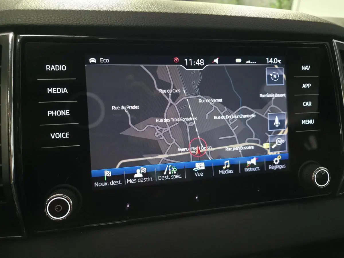 Écran tactile multimédia du tableau de bord du Skoda Karoq rouge, affichant la navigation GPS en mode carte.