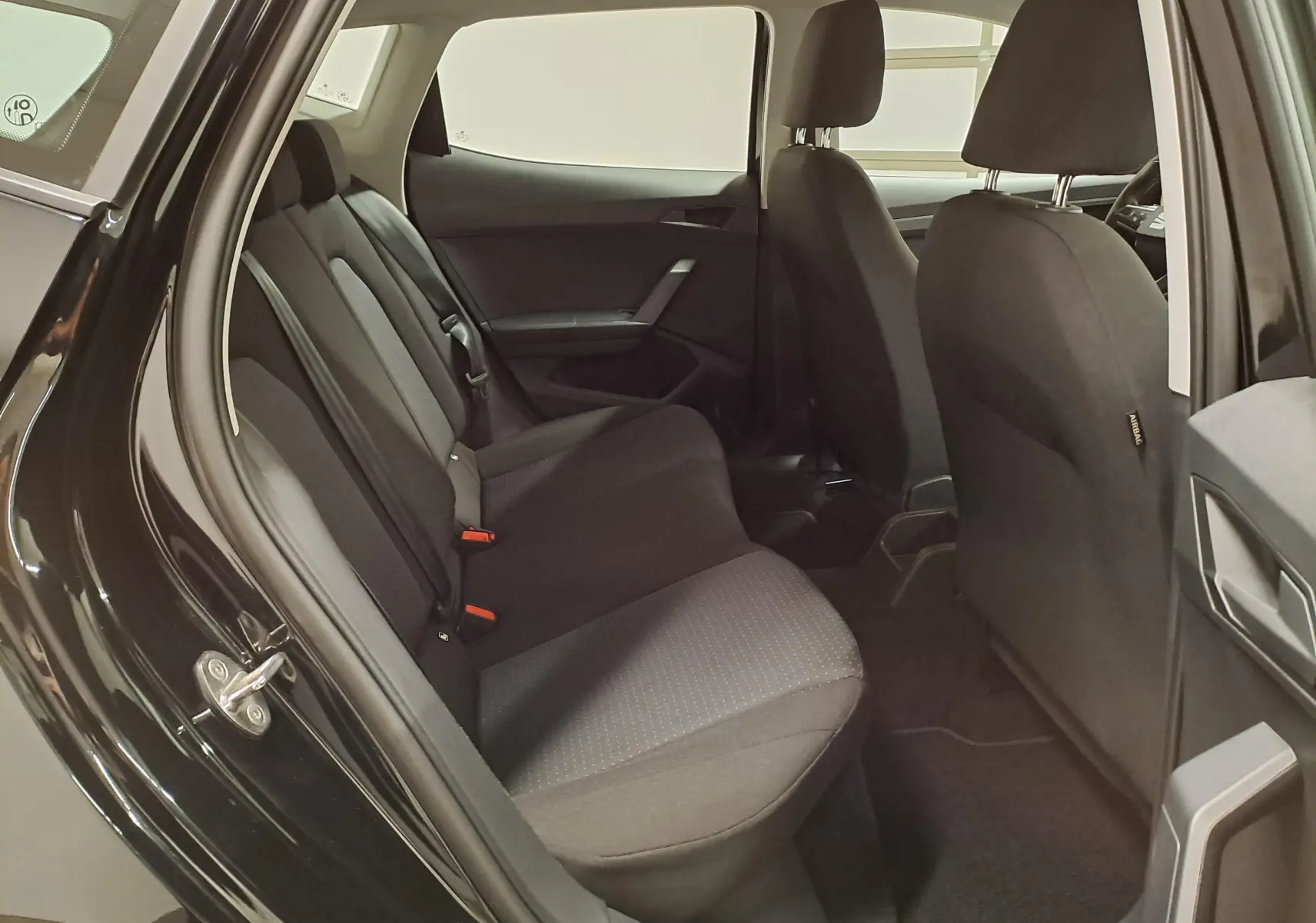 Vue intérieure côté arrière droit de la SEAT IBIZA 2024 noir minuit, montrant les sièges arrière en tissu et les appuie-têtes.