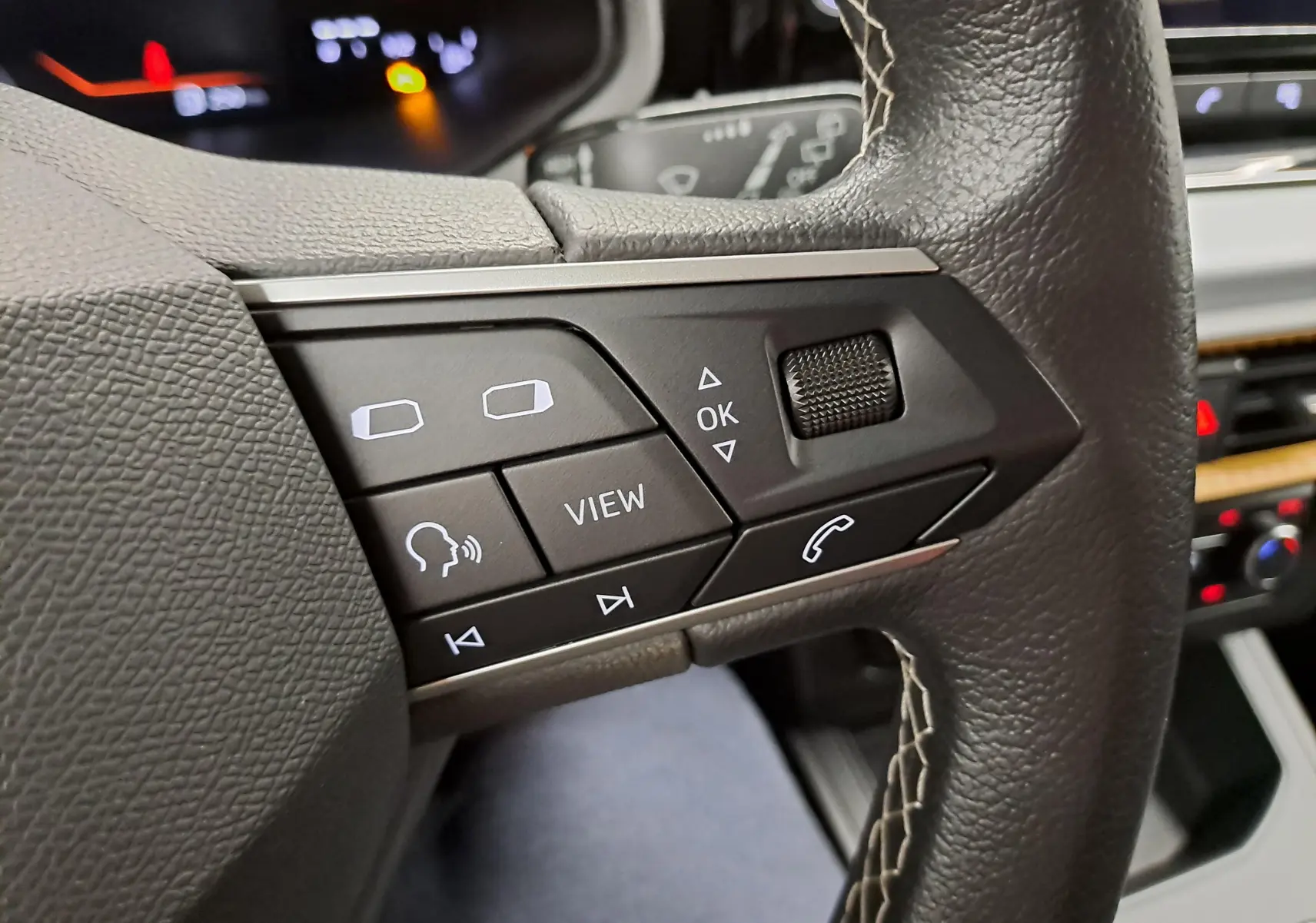 Gros plan sur les commandes multifonctions côté gauche du volant en cuir noir de la SEAT Ibiza 2024 finition Style.