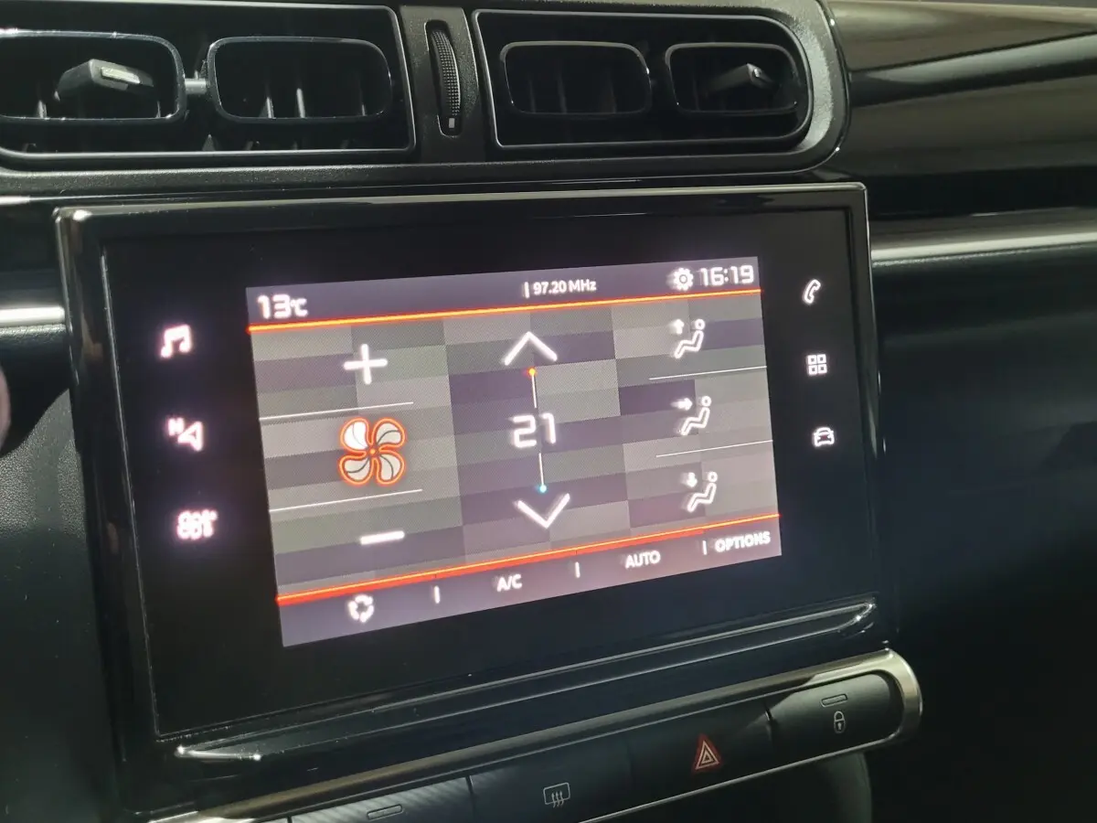 Vue rapprochée de l'écran tactile central de la Citroën C3 beige 2022 affichant la climatisation à 21°C.