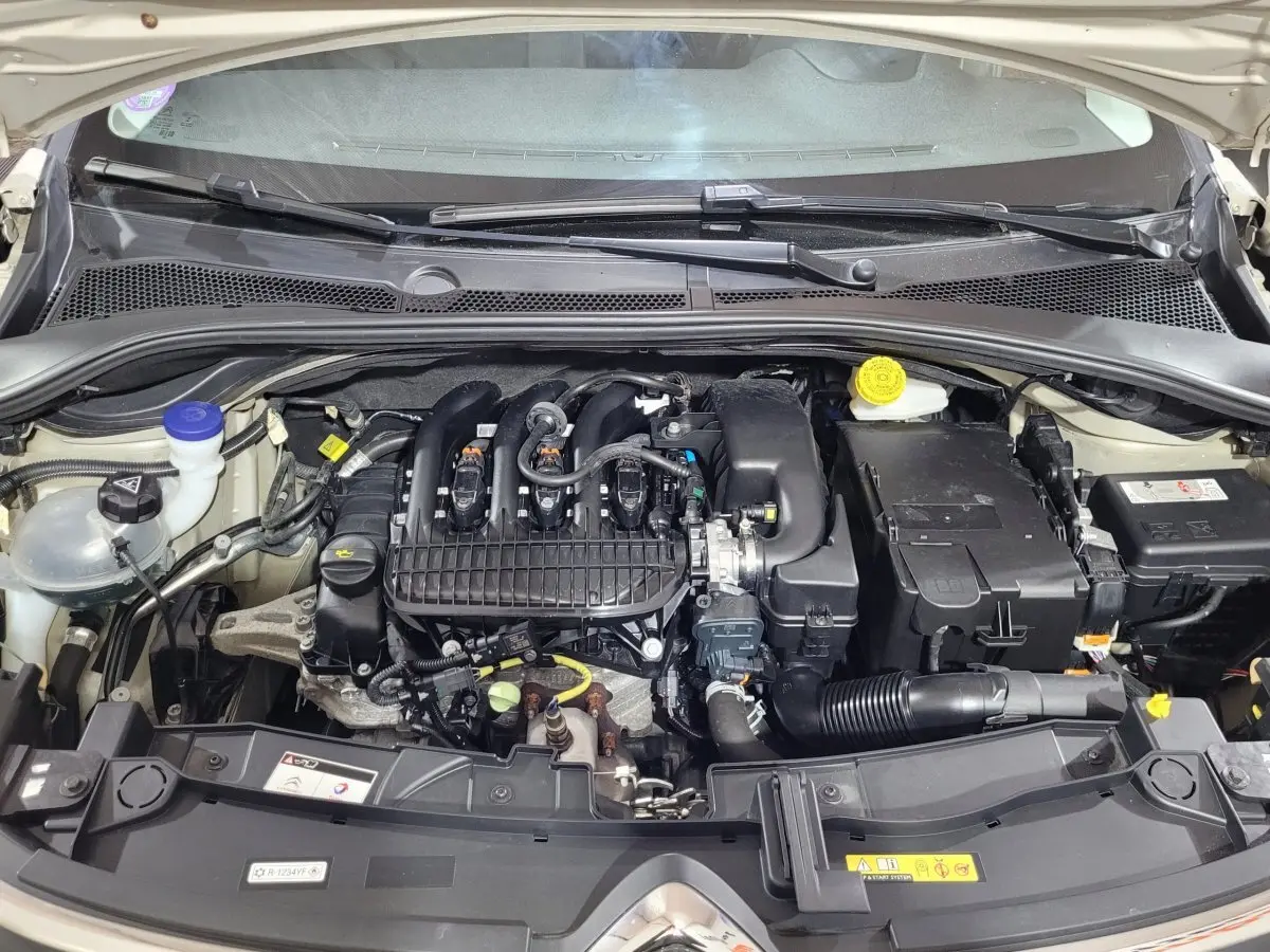 Vue rapprochée du moteur essence d'une Citroën C3 beige 2022, montrant les composants sous le capot ouvert.