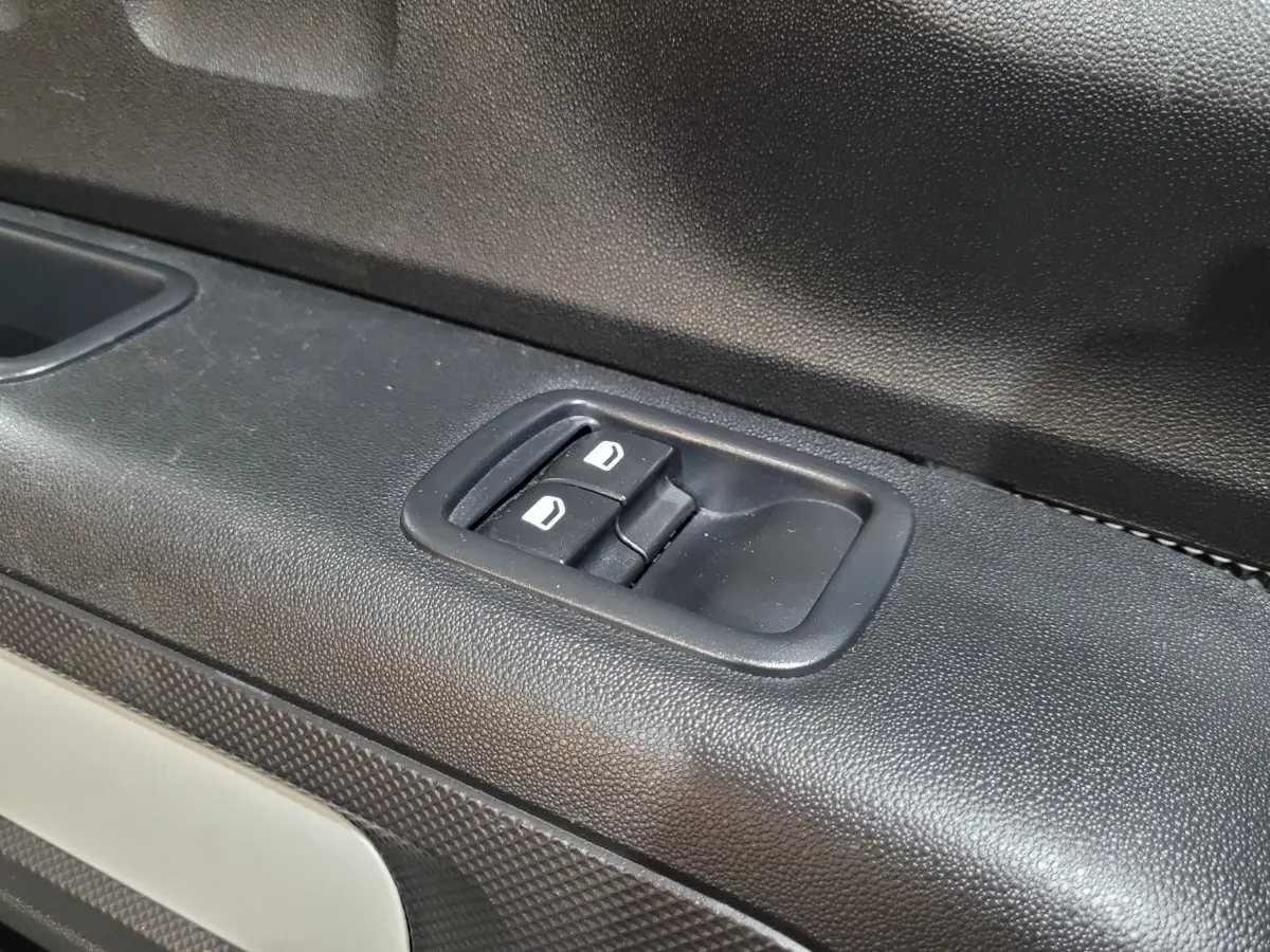 Gros plan sur les commandes de lève-vitres côté gauche d'une Citroën C3 beige, finition Feel Pack 2022.