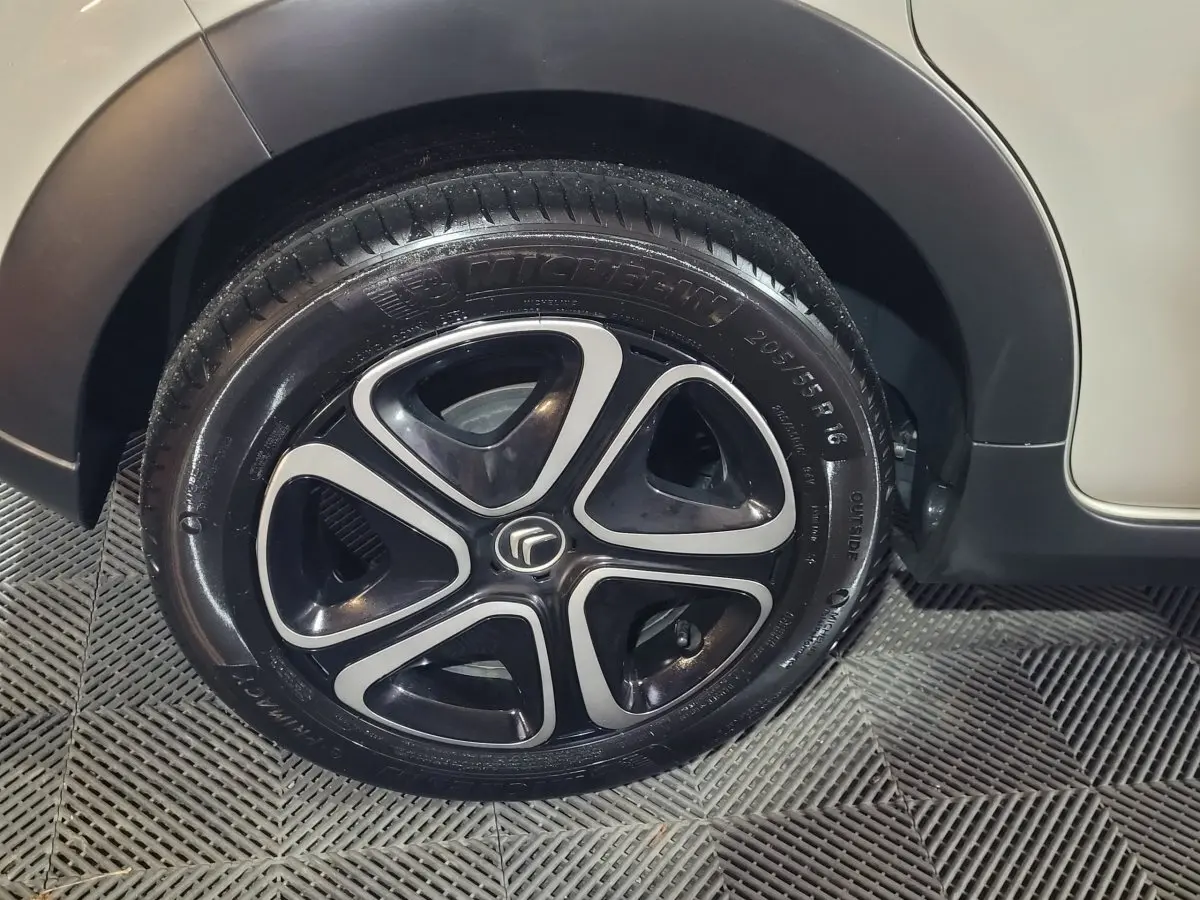 Gros plan sur la roue avant droite beige d'une Citroën C3 2022 avec jante alliage noire et argentée.