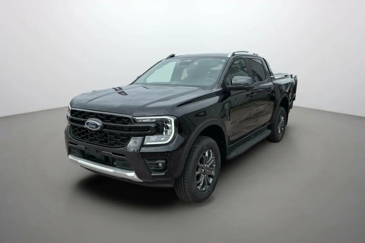 Ford Ranger 2025 noir agate en 3/4 avant droit, avec jantes alu 18 pouces et barres de toit visibles.