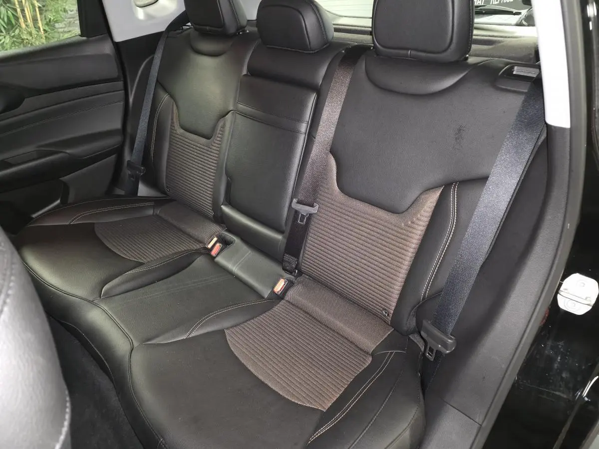 Vue intérieure côté arrière droit montrant la banquette mixte tissu/TEP noire et bronze du Jeep Compass 2024.