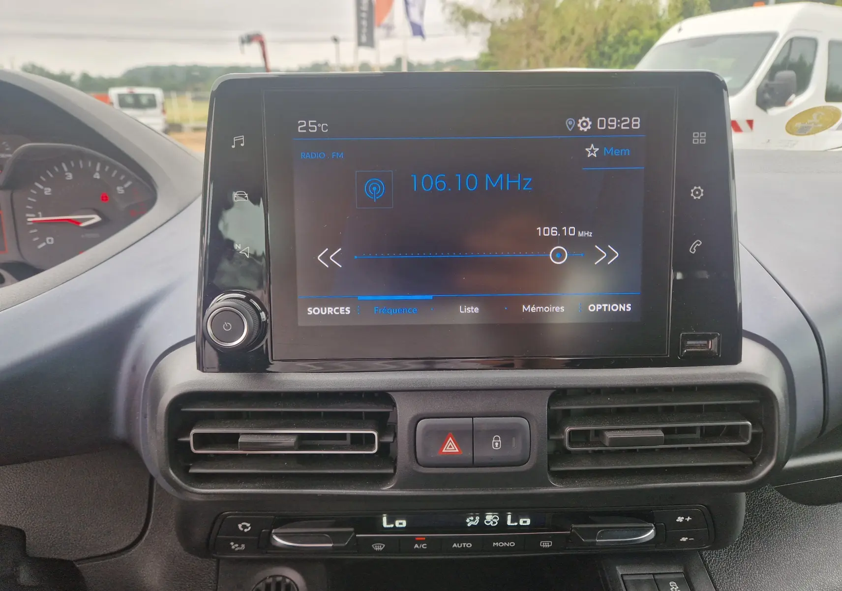 Vue intérieure centrée sur l’écran tactile multimédia du Peugeot Rifter gris platinium, affichant la radio FM à 106,10 MHz.