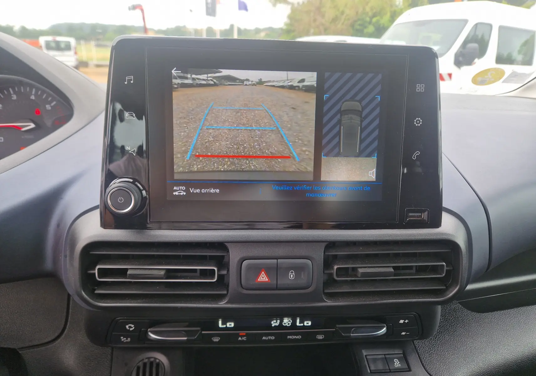 Vue intérieure du tableau de bord du Peugeot Rifter gris platinium 2019, avec écran tactile affichant la caméra de recul.