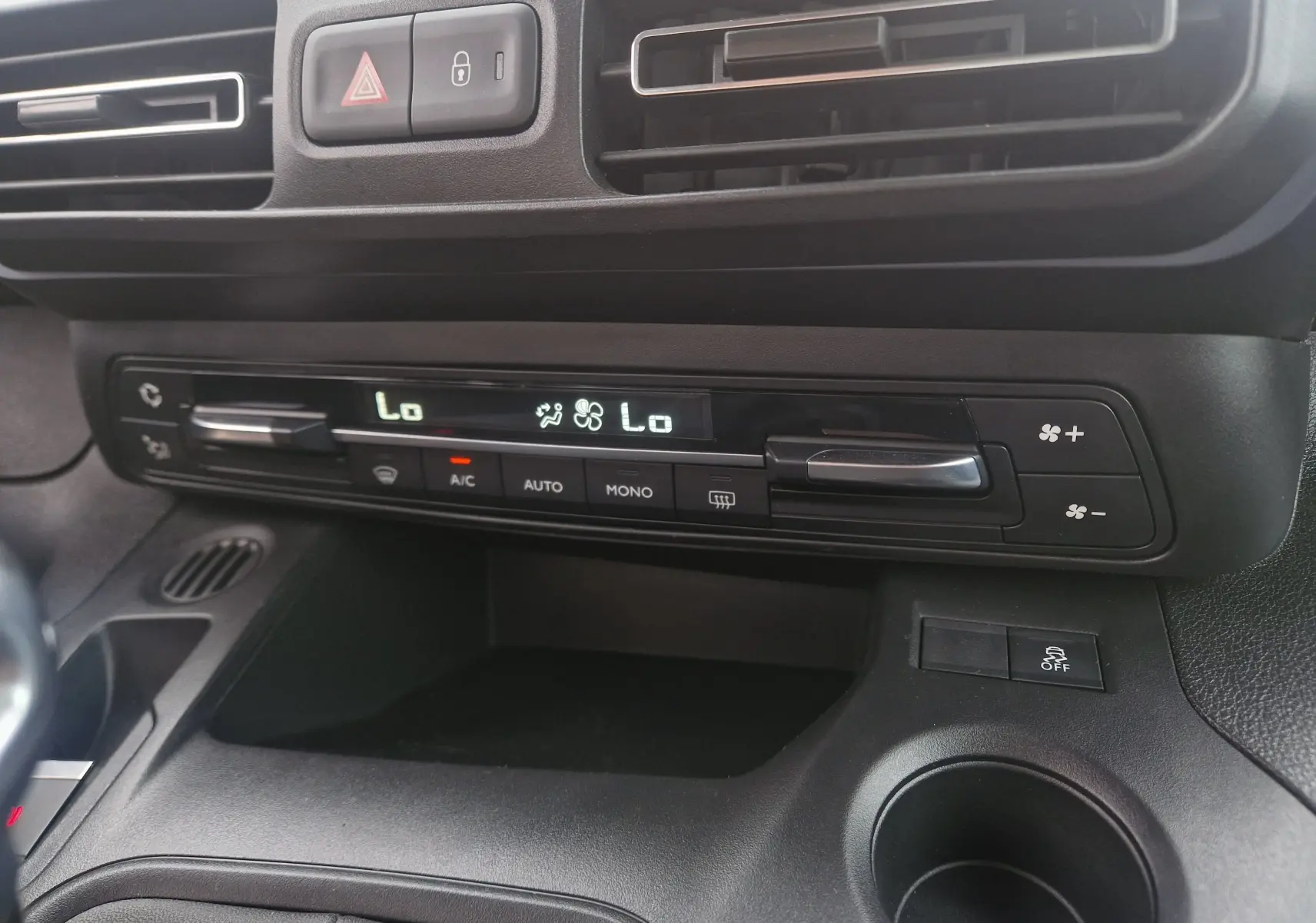 Vue rapprochée du tableau de bord du Peugeot Rifter gris platinium 2019, mettant en valeur la commande de climatisation digitale.