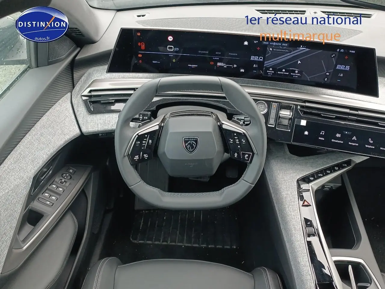 Vue intérieure du tableau de bord et volant cuir multifonction du Peugeot 5008 Hybrid 145 allure 2025 en gris artense.