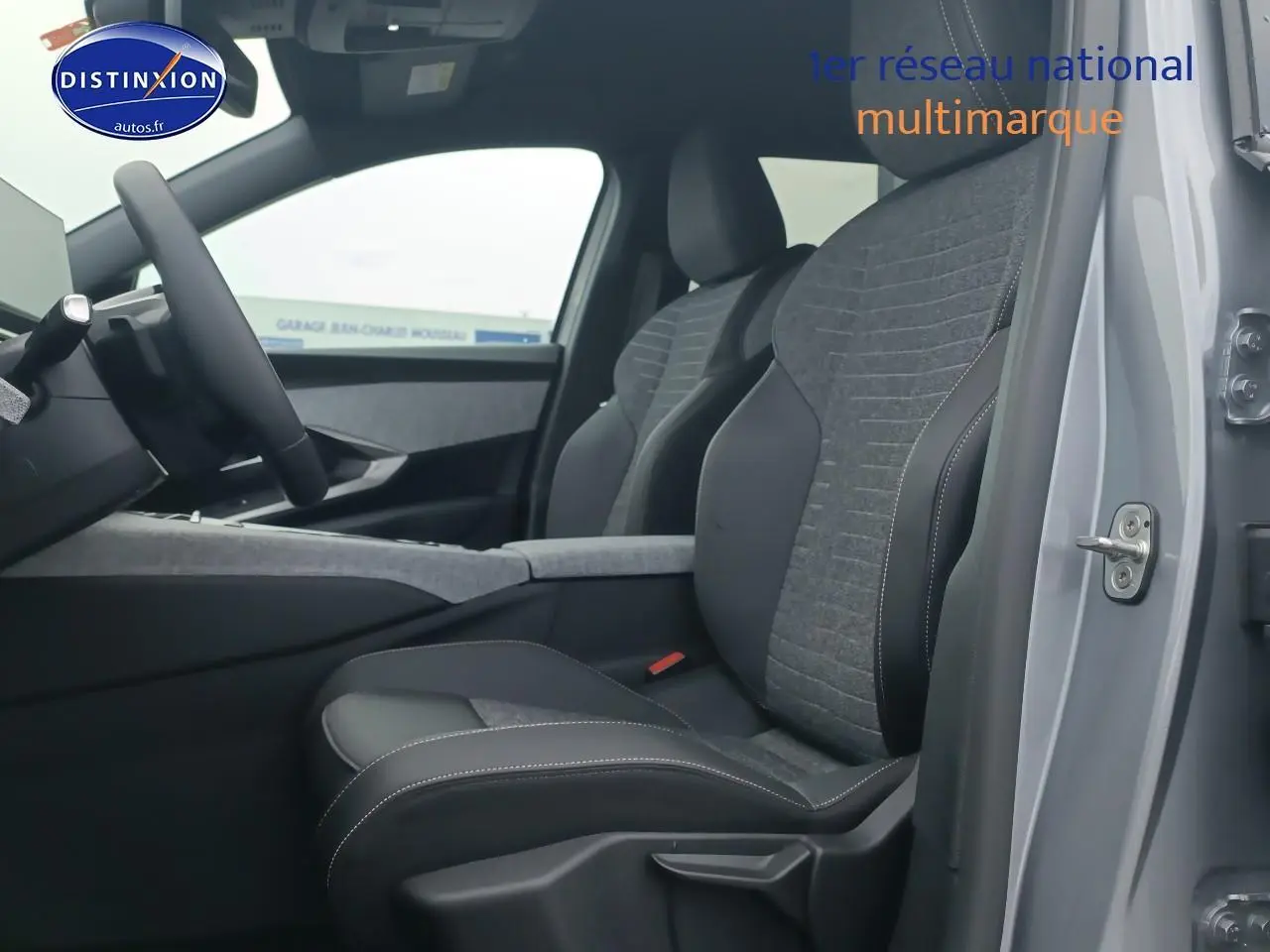 Vue intérieure côté conducteur du Peugeot 5008 gris artense, mettant en valeur les sièges tissu et cuir et le volant multifonction.
