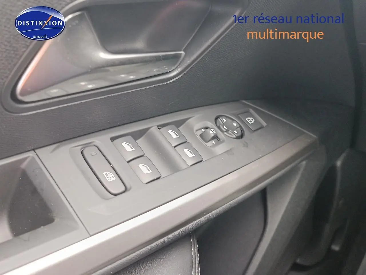 Vue rapprochée des commandes des vitres et rétroviseurs sur la porte côté conducteur d’un Peugeot 5008 gris Artense.