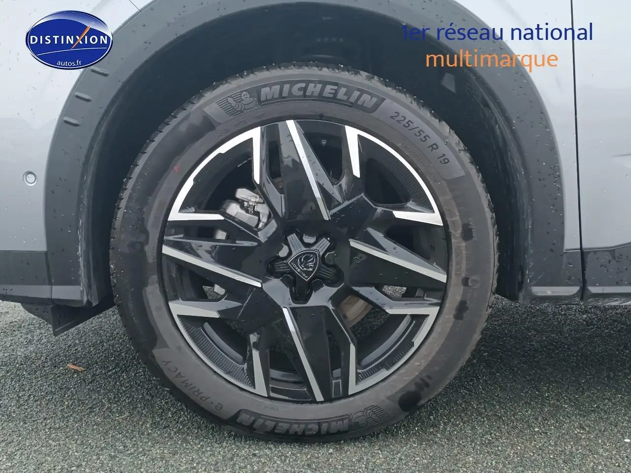 Gros plan sur la roue avant gauche du Peugeot 5008 gris Artense avec jante alliage noire et détails argentés.