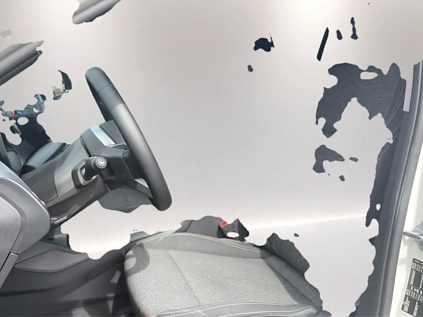 Intérieur de la BMW Série 1 120da 2025, vue côté conducteur sur le siège et le volant cuir noir.