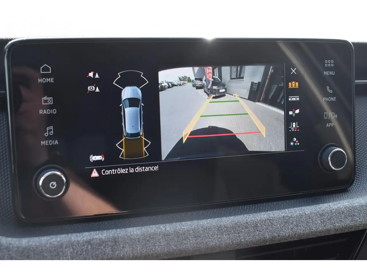 Écran central montrant la caméra de recul et les capteurs de distance du Skoda Scala gris graphite, vue intérieure.