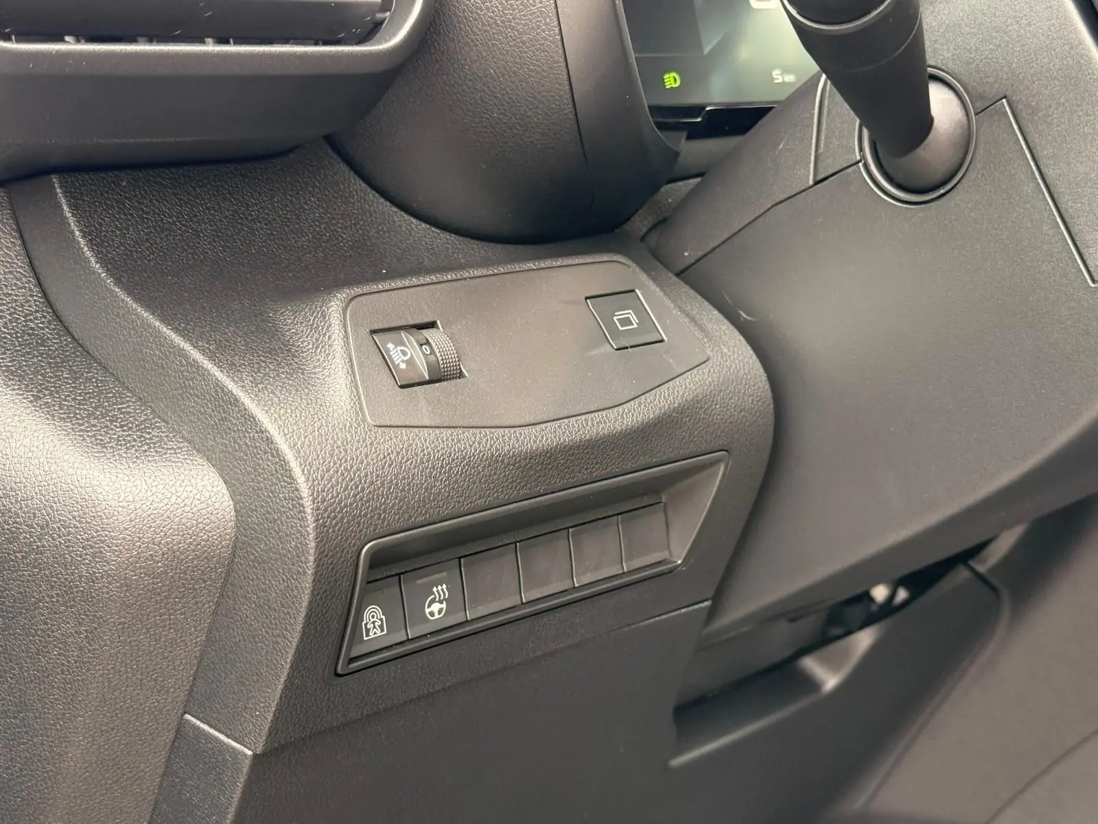 Détail des commandes côté gauche du tableau de bord du Citroën Berlingo gris Artense 2025, avec réglage luminosité et boutons chauffants.