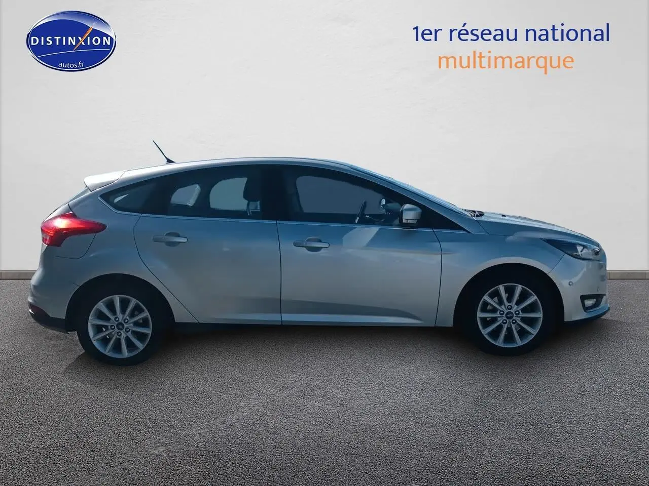 Profil côté gauche d'une Ford Focus gris clair 2017 avec jantes alu sur fond neutre.