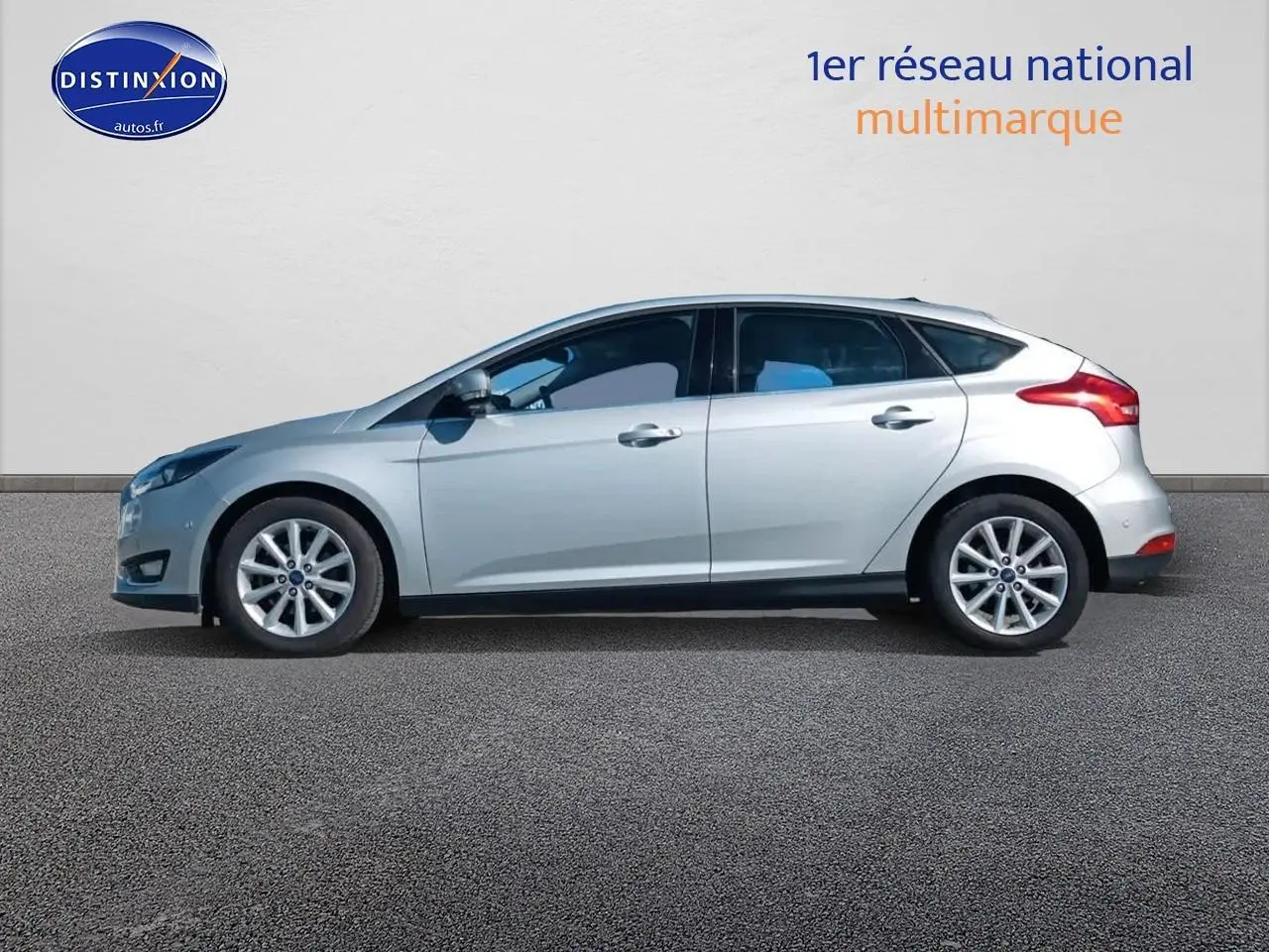 Profil latéral droit d'une Ford Focus gris clair 2017 avec jantes alu et becquet arrière visible.