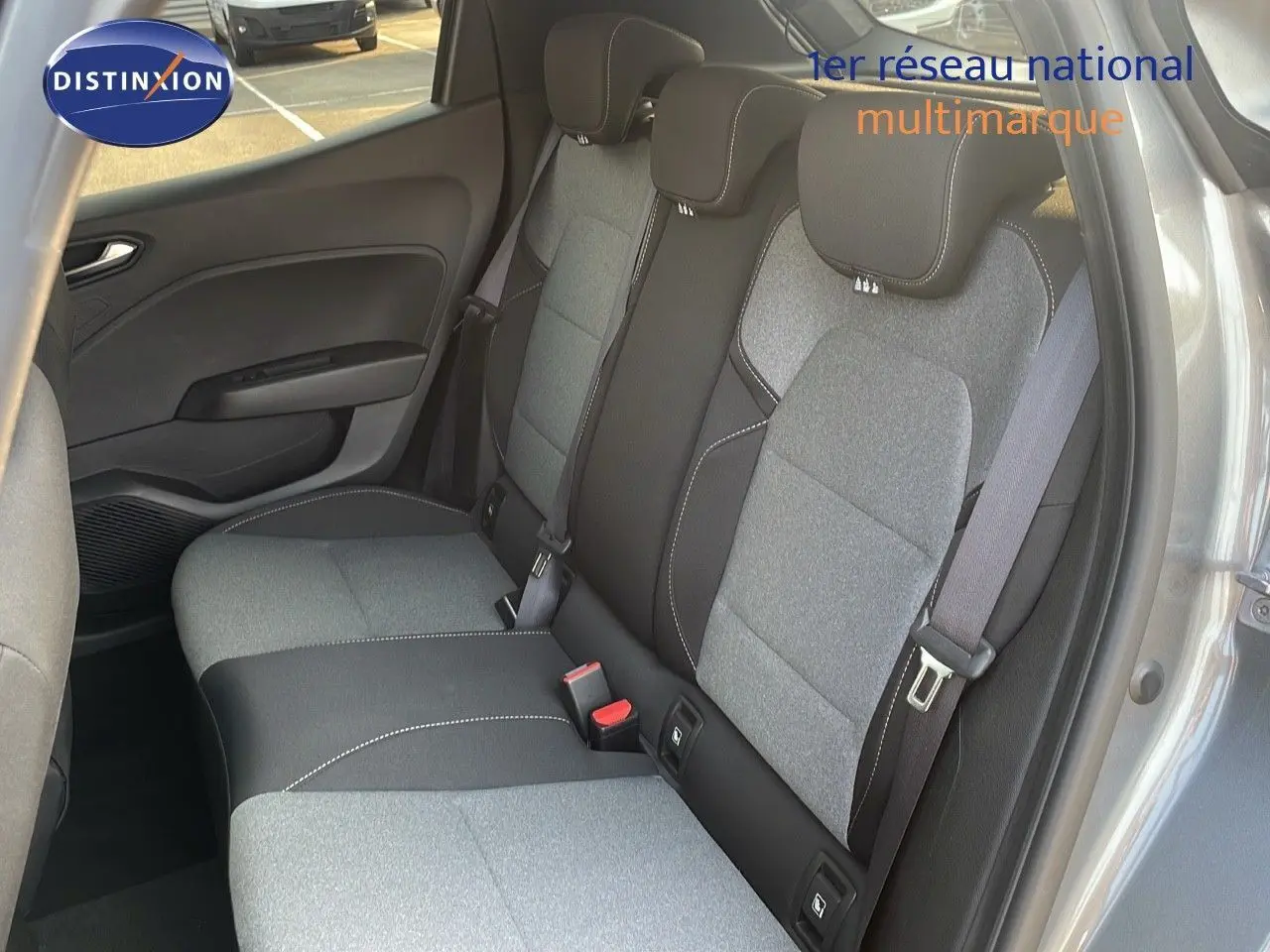 Vue intérieure côté arrière droit montrant les sièges arrière gris clair et noir de la Renault Clio 1.5 DCI Evolution 2025.