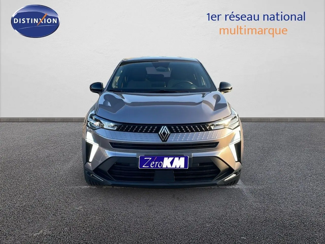 Vue frontale du Renault Captur E-Tech hybride 2025 en gris cassiopée métal avec éclairage LED allumé.