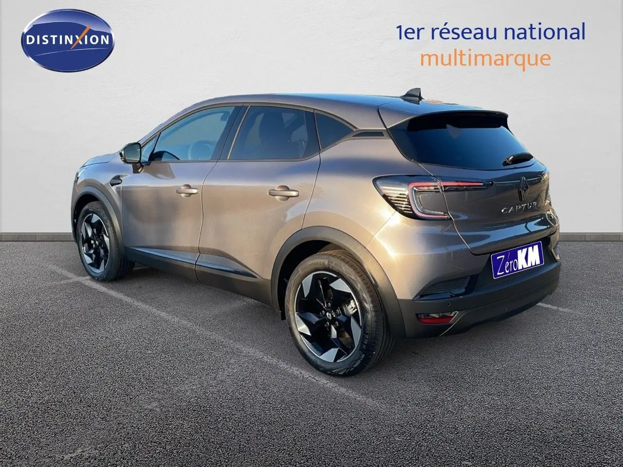 Renault Captur E-Tech hybride gris cassiopée métal vu en 3/4 arrière côté gauche avec jantes noires distinctives.